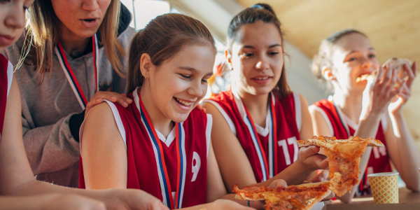 girls sports team eating pizza together
