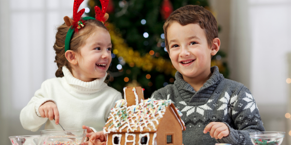 two kids decorating a gingerbread house