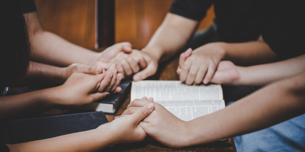 Group of 4 people in a prayer circle